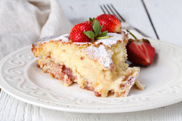 istock Cut of fresh pie with strawberry on wooden table 986573712