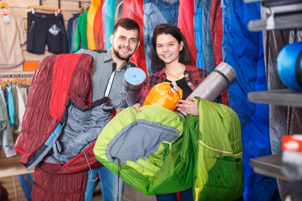 istock Young couple demonstrating tourist equipment 986574754
