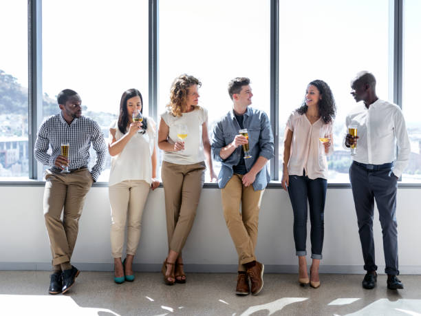istock Business people having alcohol at window in office 986580722