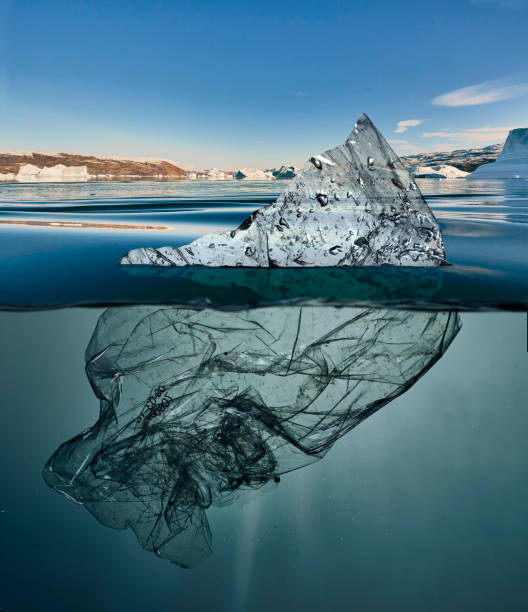 iceberg of garbage plastic floating in ocean with greenland back stock photo