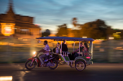 a Tuk Tuk Taxi in front of the Royal Palace at the Sisowath Quay at the Tonle Sap River in the city of Phnom Penh of Cambodia.  Cambodia, Phnom Penh, November, 2017,