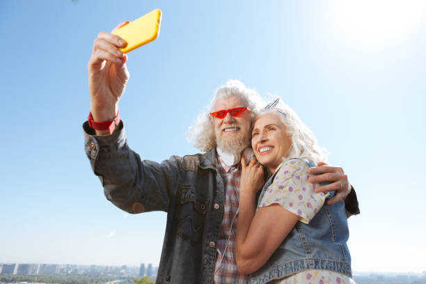 istock Cheerful positive man holding a smartphone 986589456