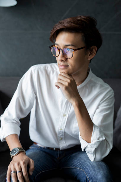 istock Young boy with glasses sitting on a sofa. 986589578