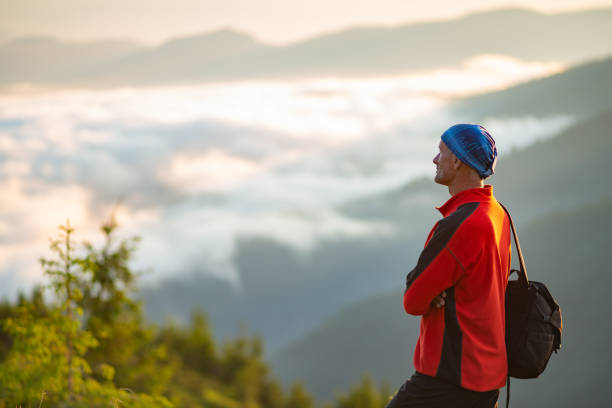 istock Happy adventurer on the mountain top during sunset 986620362