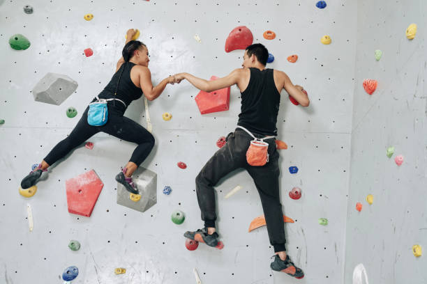 parede de escalada de desportistas de apoio acima - climbing rock climbing women determination - fotografias e filmes do acervo