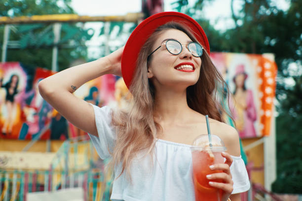 istock Beautiful young woman holding a drink while smiling 986621518