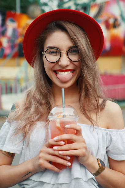 istock Cheerful young woman holding a drink while smiling 986624044
