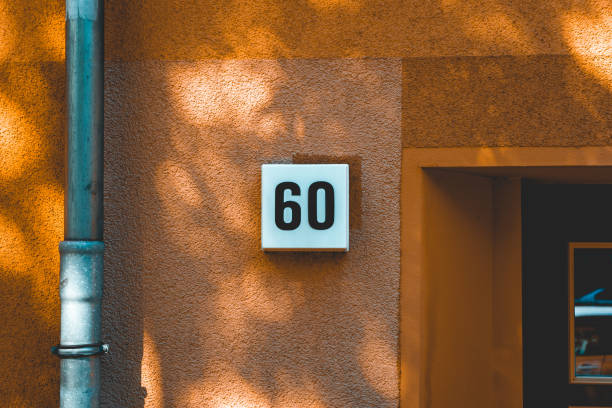 istock number 60 door sign on orange facade with some light leaks 986627926