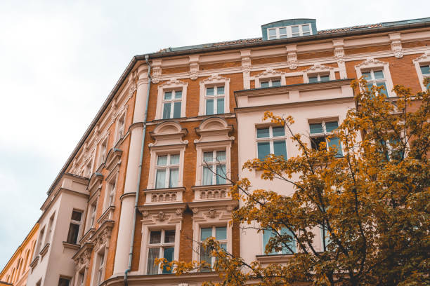 istock orange brick facaded apartment building with autumn tree in the frontside 986628130