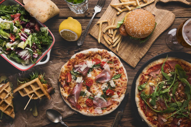 istock Fast food on old wooden background. 986629278