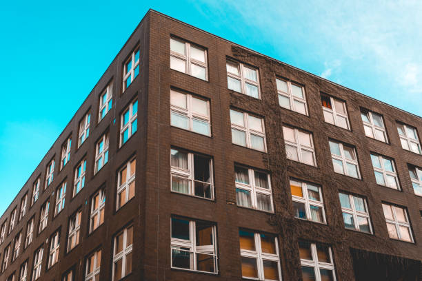 istock brown facaded brick building with white square windows 986629676