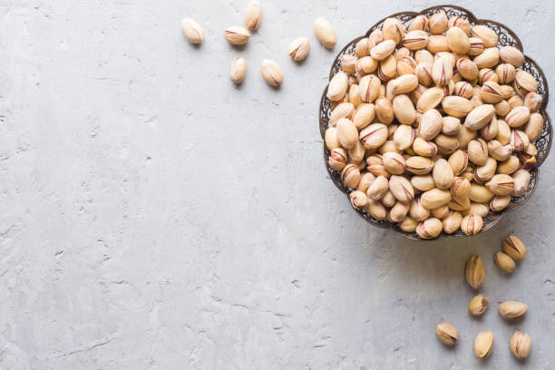 istock Delicious salted pistachios on a plate Copy space 986632022
