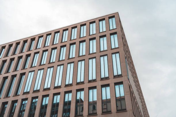 istock modern office building with grey facade and long windows on a cloudy background 986634468