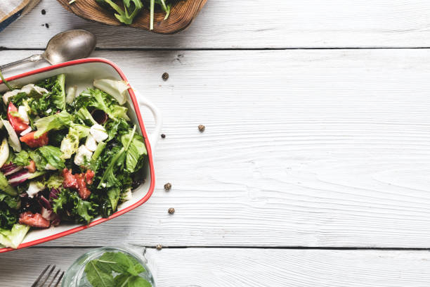 salad on white wooden table close up of a salad with copy space from above spring mix lettuce leaves stock pictures, royalty-free photos & images