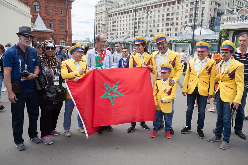 MOSCOW, RUSSIA - JUNE 21, 2018: Colombian and Moroccan football fans holding the Moroccan flag in the Revolution Square during the 2018 World Cup. The Revolution Square is located in the center of Moscow.