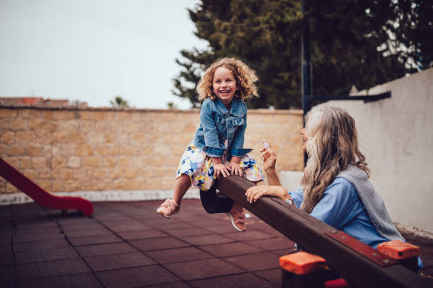 garota feliz se divertindo brincando com a avó no playground - great granddaughter - fotografias e filmes do acervo