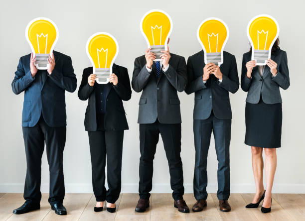 istock Business people holding lightbulb icons 986650656
