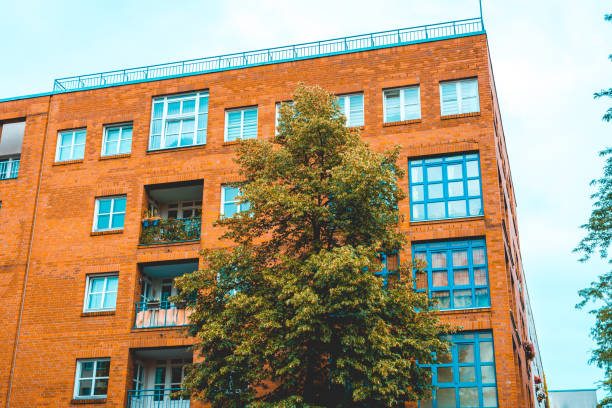 istock orange brick building with green tree in the foreground 986656240
