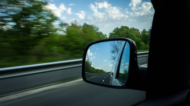 istock car side mirror of a fast moving car and blurred background. 986657080