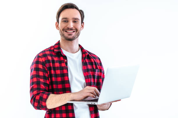 istock The happy man with a laptop standing on the white background 986657494