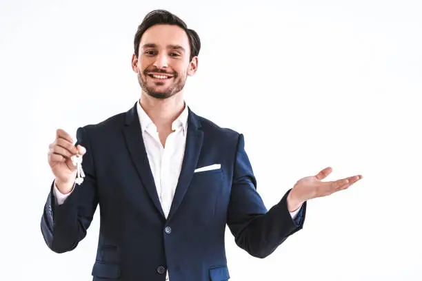 Photo of The happy businessman holding keys on the white background