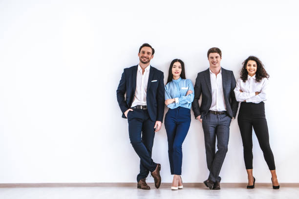 The business people standing on the white wall background stock photo