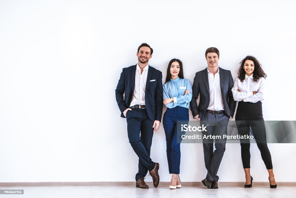 Pessoas de negócios, de pé sobre o fundo de parede branca - Foto de stock de Grupo de Pessoas royalty-free