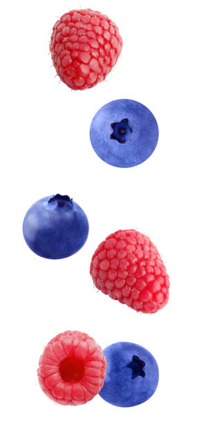 istock Flying raspberry and blueberry fruits isolated on white 986665728