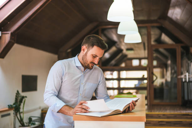 istock Portrait of an happy man reading a book 986678518