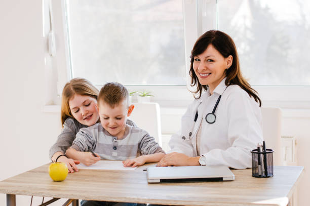 istock Doctor with little kids in office. 986678632