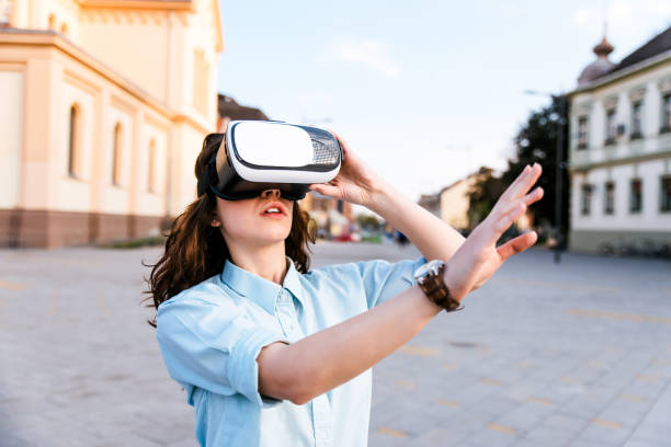 istock Young beautiful woman using VR outside. 986678818