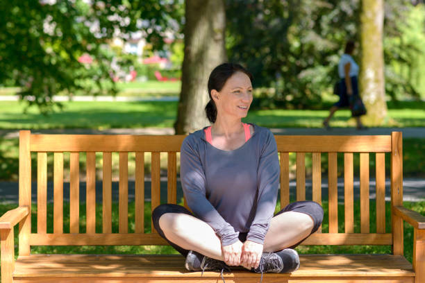 istock Attractive supple woman sitting on a park bench 986679520