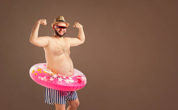 istock Thick funny man with a beard with a circle for swimming 986682998