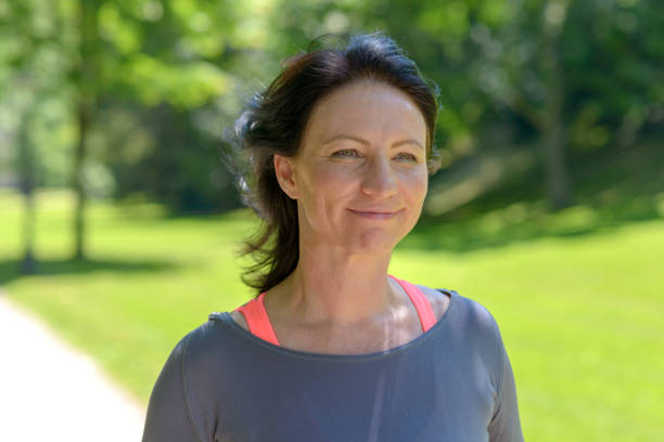 istock Smiling woman jogging in park 986685862