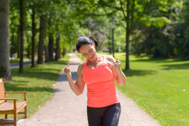 begeisterte reife frau im park laufen - running track women running spring stock-fotos und bilder