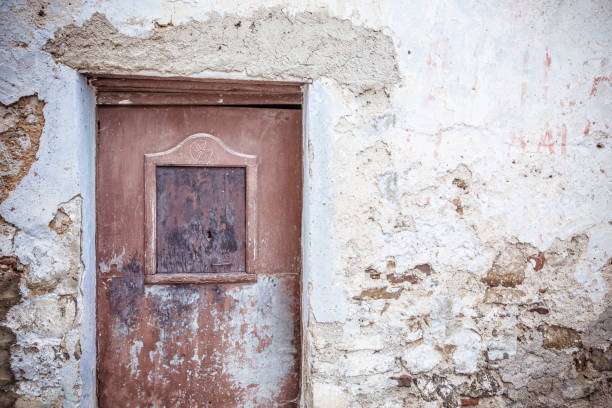 istock Old brown door and weathered stone wall 986686650