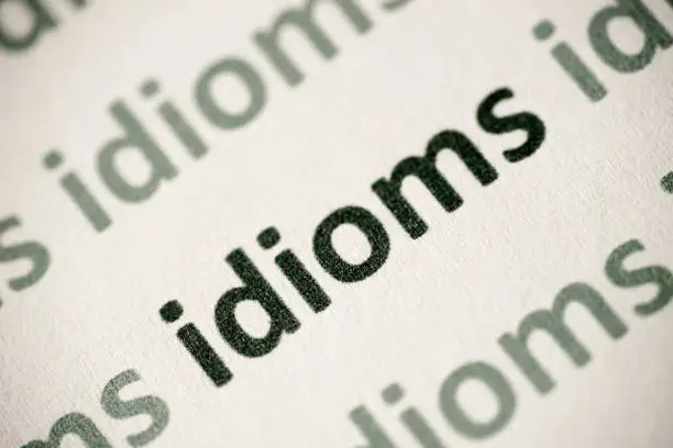 Photo of word idioms printed on paper macro