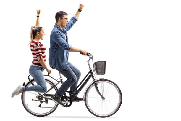 istock Young couple riding a bicycle and gesturing happiness 986687082