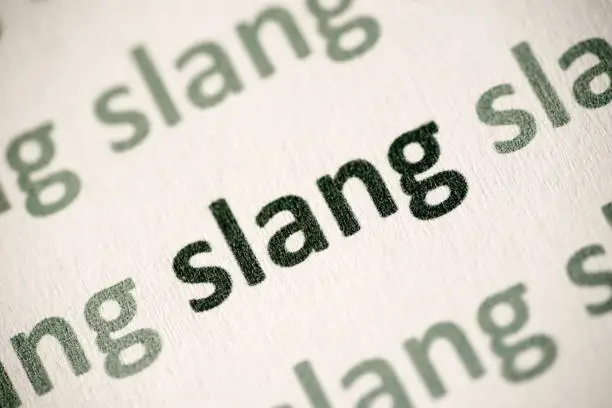 Photo of word slang printed on paper macro