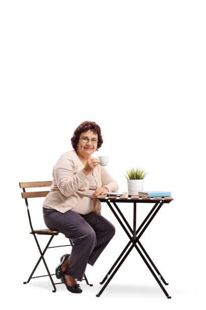 istock Mature woman sitting at a coffee table 986687810