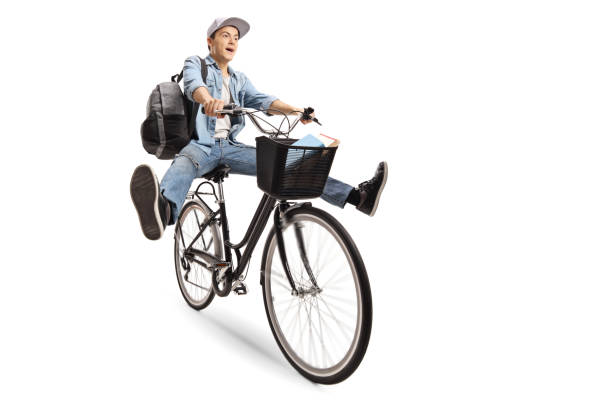 istock Joyful teenage boy with a backpack riding a bicycle 986687902