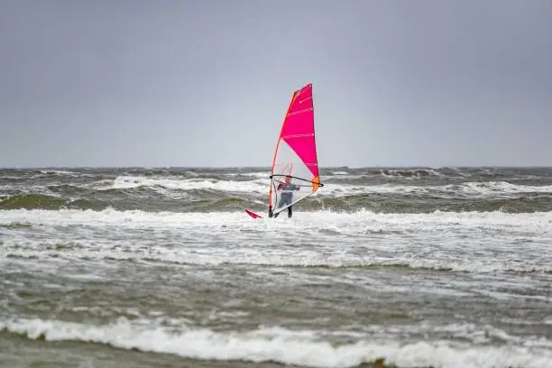 Man windsurfing on cloudy windy cold day on Romo Island in Denmark