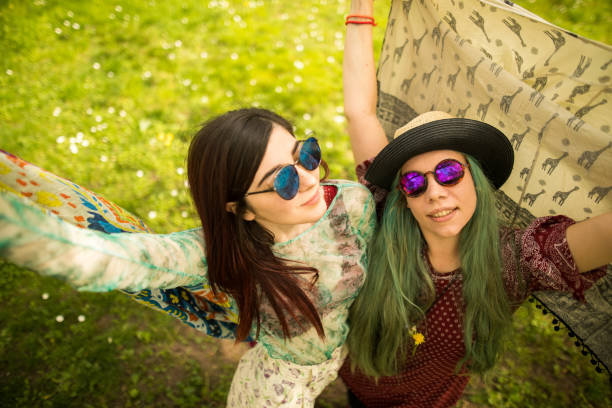 istock Two hippie women playing with their scarves 986696368