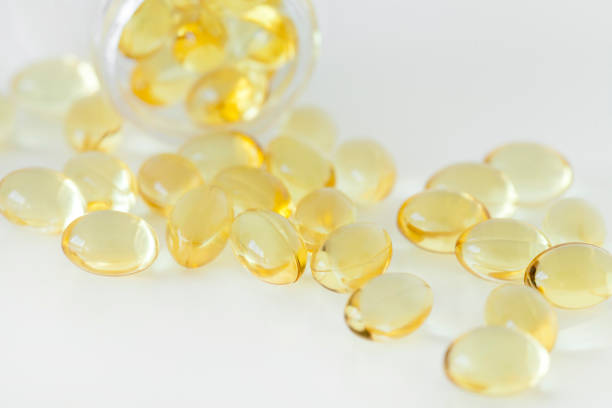 白い背景に分離された黄色のソフトなジェル薬の山 - gel pill ストックフォトと画像