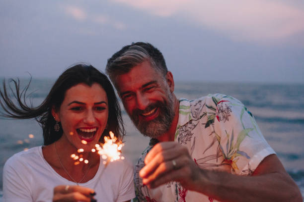 istock Couple celebrating with sparklers at the beach 986704502