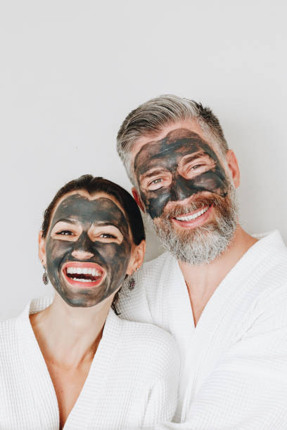 istock Happy couple wearing a charcoal mask 986705230