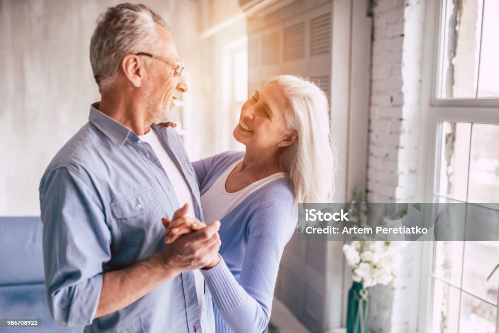 A mulher idosa sorridente e um homem dançando - Foto de stock de Terceira idade royalty-free