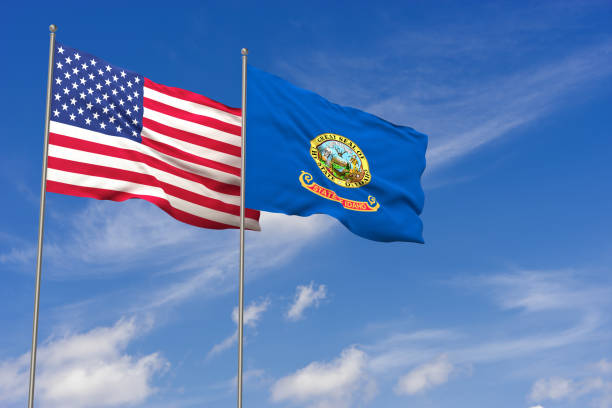 istock USA and Idaho flags over blue sky background. 3D illustration 986709956