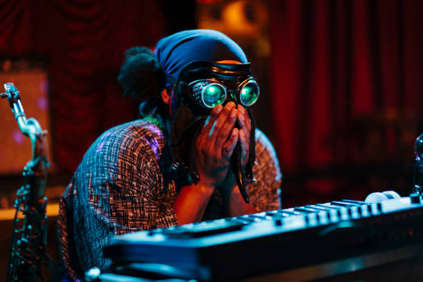 istock Man with mask playing music on stage 986710110
