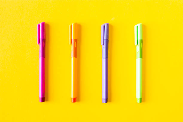 istock Multicolored four pen for writing on a yellow background . Top view, flat lay. Minimal chancery concept 986720334